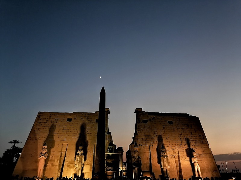 Luxor temple lit up at night with obelisk silhouette