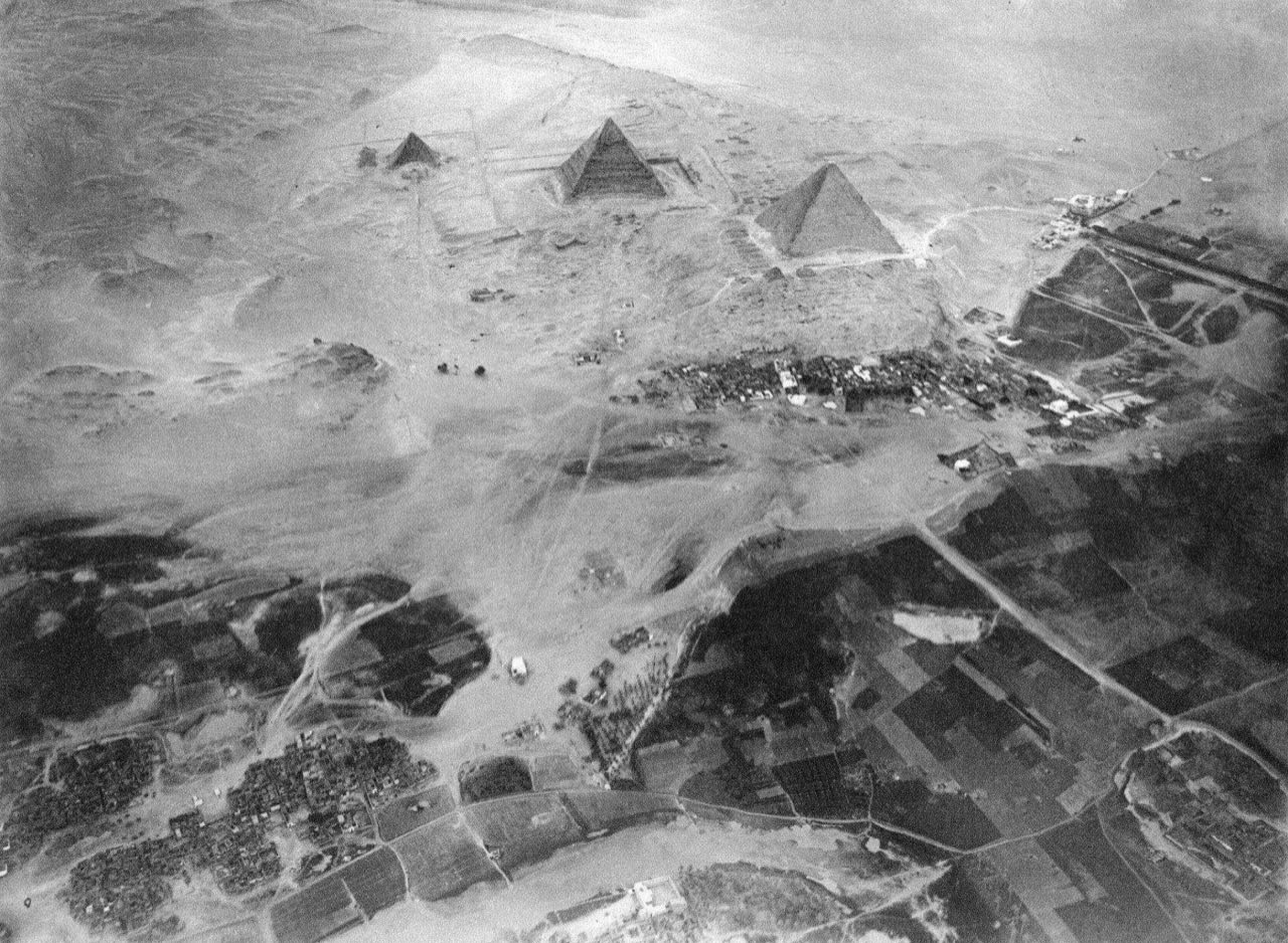 The three Giza Pyramids at dusk against an orange sky